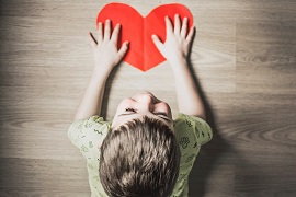 boy holding red paper heart