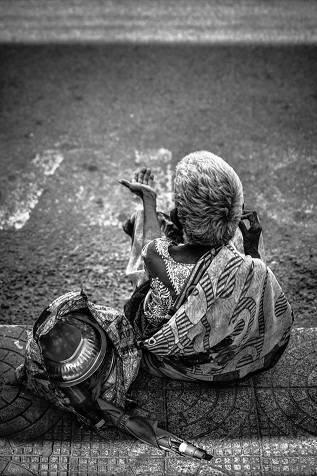 Photo on Unsplash, grayscale old man sitting at roadside